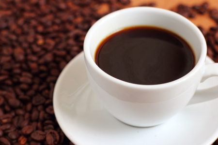 White cup of coffee on coffee beansの写真素材