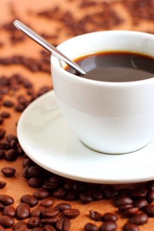 Cup of coffee with coffee beans and spoonの写真素材