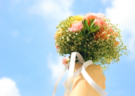 Bouquet of flower in hand and blue sky の写真素材