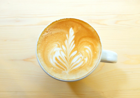 Latte art coffee on wooden tableの写真素材