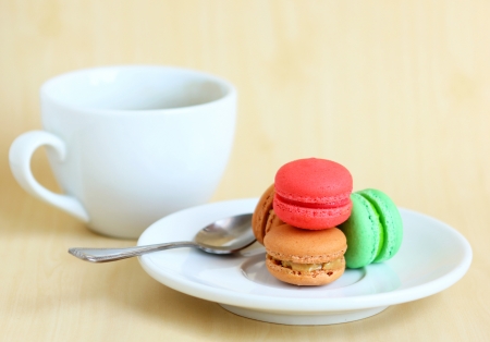 Colorful macaroons and a cup of coffee with spoonの写真素材