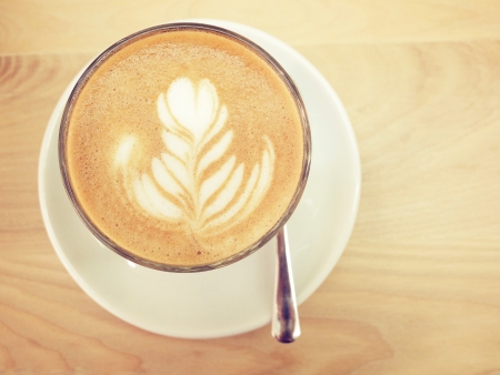 Cappuccino or latte coffee on table with retro filter effectの写真素材