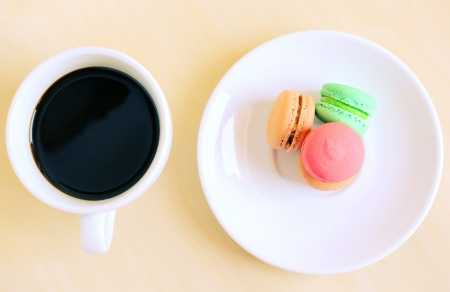 Colorful macaroons and cup of coffee with retro filter effectの写真素材