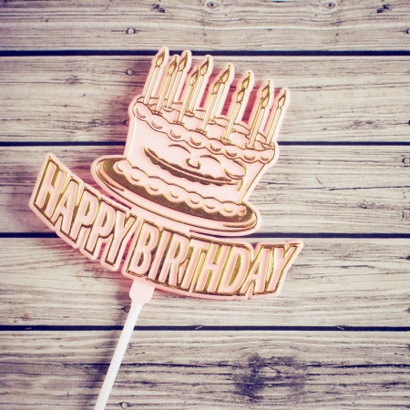 Happy birthday on wooden background with retro filter effectの写真素材