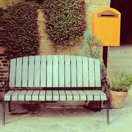 Wooden chair with vintage mailbox in garden, retro filter effectの写真素材