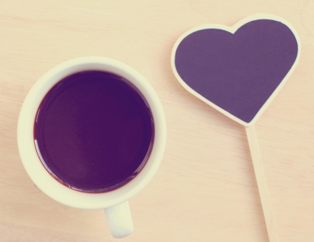Black coffee and heart shape blackboard with retro filter effectの写真素材