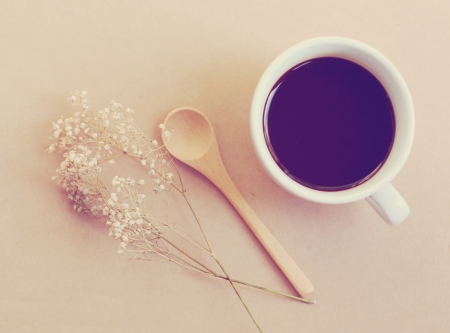 Black coffee and spoon with dried flower, retro filter effectの写真素材