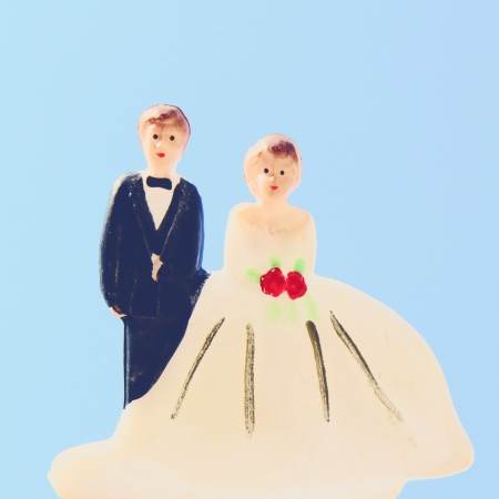 Groom and bride couple doll on wedding cakeの素材
