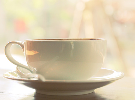 Closeup of coffee cup on table at coffee shop with retro filter effect の写真素材