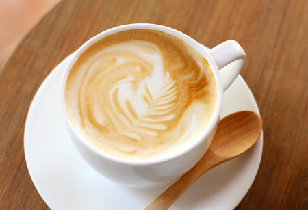 Cup of latte or cappuccino coffee with wooden spoonの写真素材