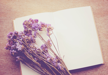 Blank notebook and dried statice flowers with retro filter effectの写真素材