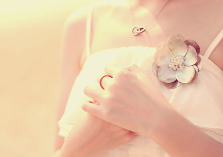 Close up of bride's hands with accessory for dress, retro filter effectの写真素材