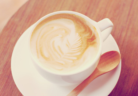 Cup of latte or cappuccino coffee with wooden spoon, retro filter effectの写真素材