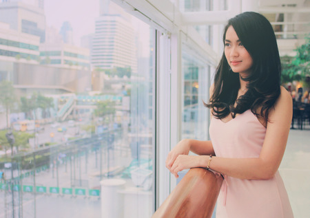 Beautiful asian business woman smiling in modern building with retro filter effect