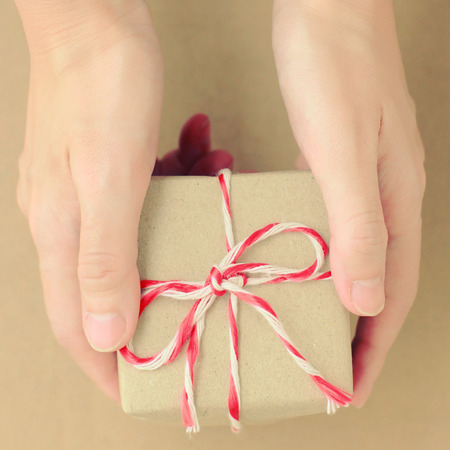 Hand holding gift box with retro filter effectの写真素材