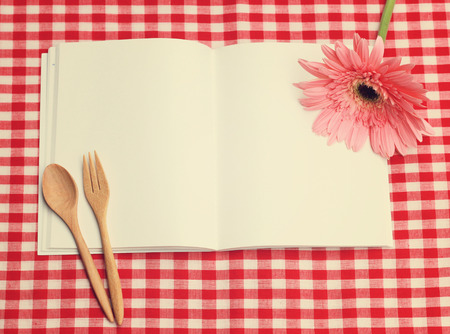 open blank recipe book on checkered tablecloth with retro filter effectの写真素材