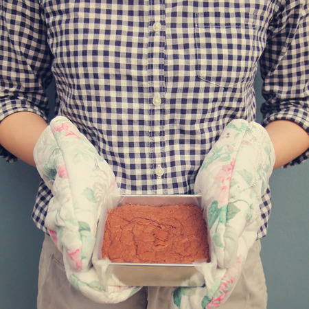 Woman holding brownie taken out of oven, retro filter effectの写真素材