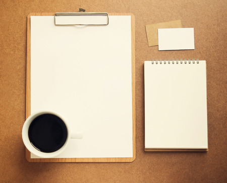 Blank white paper on clipboard and notebook with cup of coffee, retro filter effectの写真素材