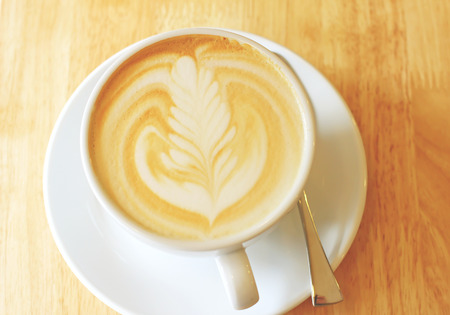 Cup of art latte or cappuccino coffee with vintage filter effectの写真素材