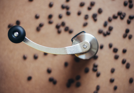 Top view of coffee grinder on coffee beans with retro filter effectの写真素材