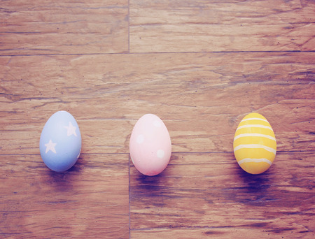Top view of colorful easter eggs on wooden background with retro filter effectの写真素材