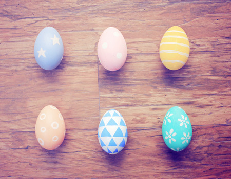 Top view of colorful easter eggs on wooden background with retro filter effectの写真素材