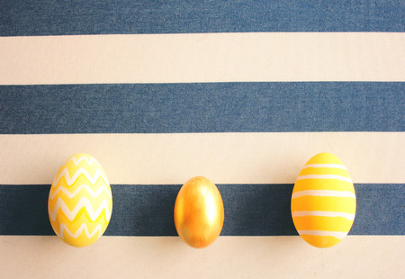 Yellow easter eggs on striped background with retro filter effectの写真素材