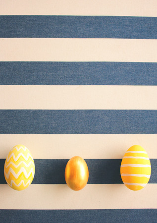 Yellow easter eggs on striped background with retro filter effectの写真素材