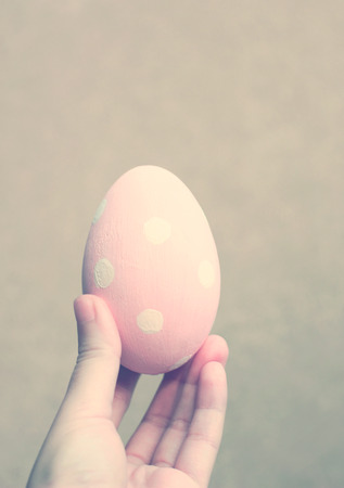 Hand holding painted easter egg with retro filter effectの写真素材