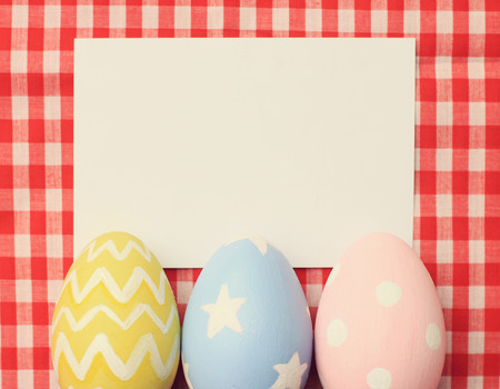 Colorful easter eggs and blank note paper with retro filter effectの写真素材