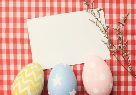 Colorful easter eggs and blank note paper with retro filter effectの写真素材
