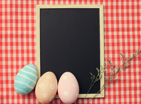 Colorful easter eggs on blank blackboard with retro filter effectの写真素材