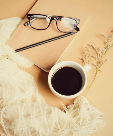 Notebook and eyeglasses with coffee, vintage filter effectの写真素材