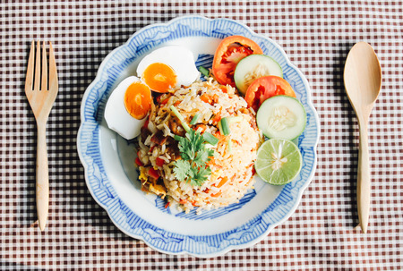 Delicious Thai fried rice with wooden spoon on tableclothの写真素材