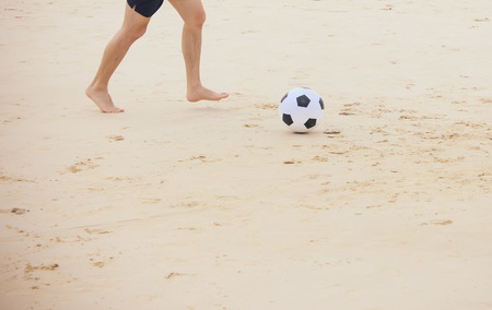 Man playing soccer ball on the beachの写真素材