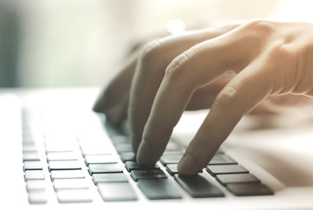 Female hands typing on laptop with retro filter effectの写真素材