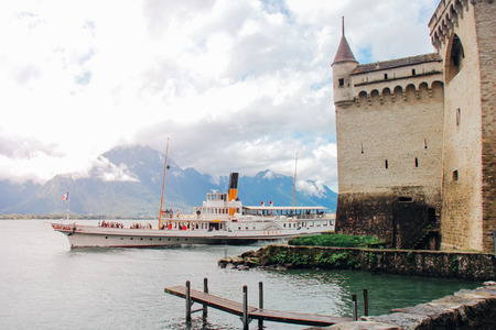 MONTREUX, SWITZERLAND - AUGUST 13, 2014: Cruise boat La Suisse on Lake Geneva with Chillon Castle in Montreux, Switzerland.のeditorial素材