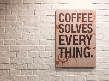 Inspirational motivating quote about coffee on canvas frame hanging on brick wall in the cafeの写真素材