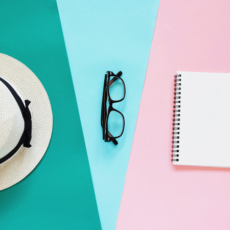 Creative flat lay photo of fashion style with eyeglasses, panama hat and notebook with copy space background, minimal styleの写真素材