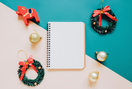 Creative flat lay of craft and blank notebook mock up with christmas ornamentsの写真素材