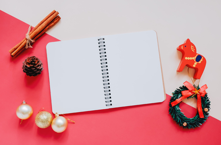 Creative flat lay of craft and blank notebook mock up with christmas ornamentsの写真素材