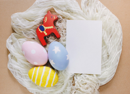 Colorful easter eggs with blank greeting card on clothの写真素材