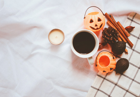 Flat lay of autumn and thanksgiving arrangement style with halloween pumpkin on white sheet blanket backgroundの写真素材