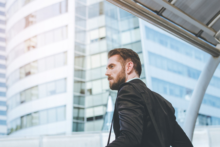 Side view of success businessman looking on modern building with copy spaceの写真素材