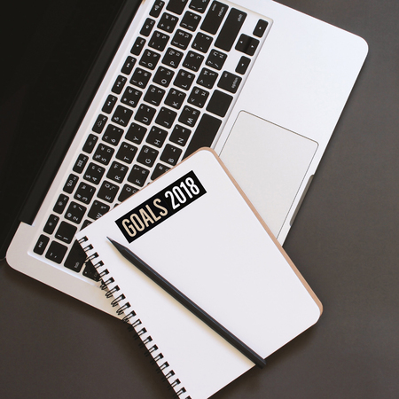 Inspirational quote word, goals for 2018 on blank notebook with laptop, top view の写真素材