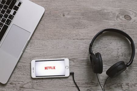 BANGKOK, THAILAND - April 28, 2018 : Top view of Netflix app icon on iphone screen with headphone and laptop. Netflix is an international leading subscription service for watching movies and TV series.のeditorial素材