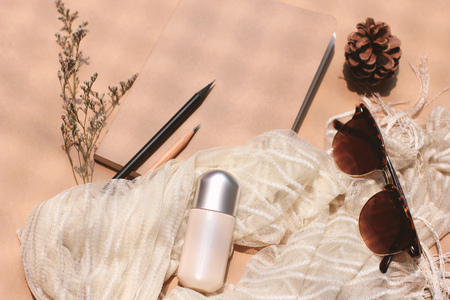 Cosmetic blank plastic tube mockup with eyeglasses and notebook with scarf, lifestyle and healthcare concept, retro style toneの写真素材