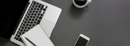 Creative flat lay design of workspace desk with laptop, notebook, smartphone and coffee with copy...
