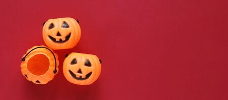 Flat lay style of halloween party concept with decorative plastic pumpkins on red background, copy space with banner style for text and templateの写真素材