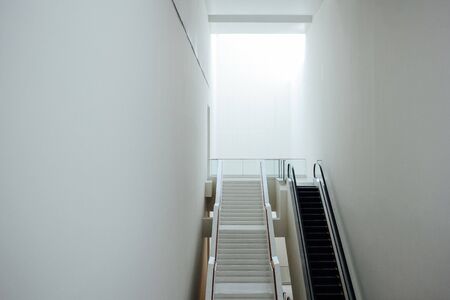 New modern escalator and stairways in minimal white building interior